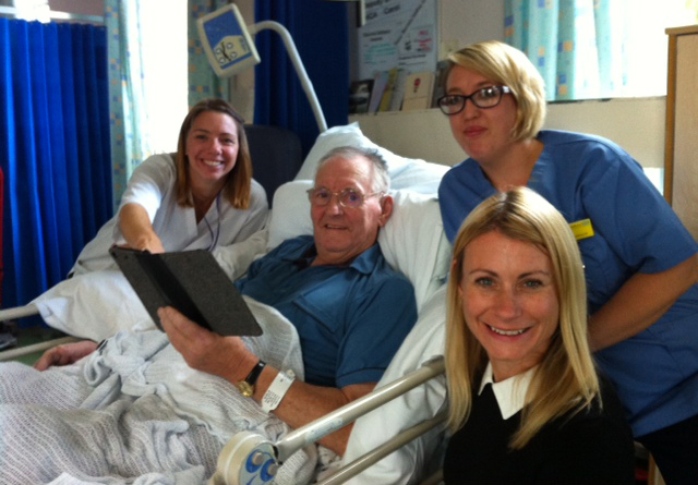 Specialist Neurological Occupational Therapist Ruth Siewruk showing a stroke patient the i-pad, Assistant Practitioner Jemma Sampson and Neuro-Rehabilitation Lead Emma Cork 